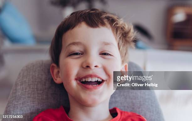 little happy boy with jam-smeared mouth laughs into the camera - happy dirty child stockfoto's en -beelden