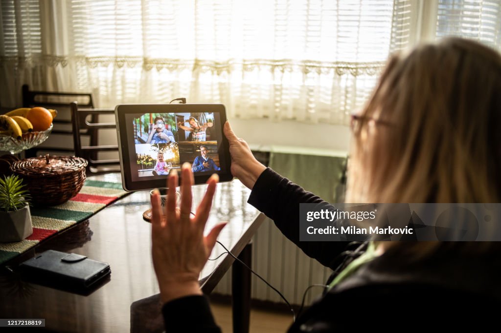 An older woman talks to her family through a video call