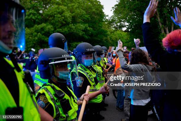 Protesters confront a row of police officers at the conclusion of a peaceful movement where they protested the death of George Floyd and other black...