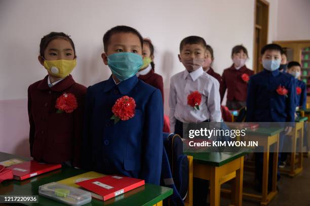 Primary school children wearing face masks as a protective measure against the COVID-19 novel coronavirus attend a class at Hasin Primary School in...