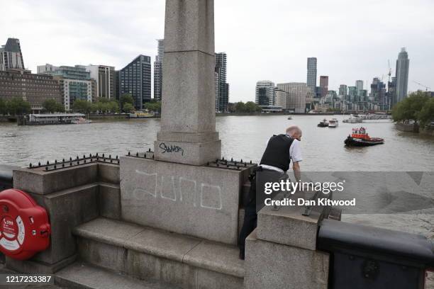 Police officer searches in the Thames for a person who has been reported as falling or jumping from Westminster Bridge on June 3, 2020 in London,...