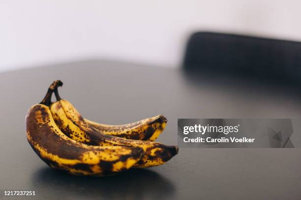 bunch of ripe, rotten bananas on a dark table - ready to eat stock pictures, royalty-free photos & images