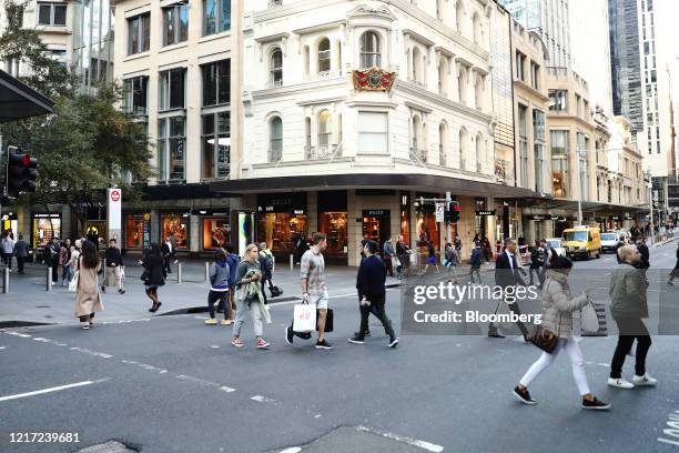 Pedestrians and shoppers cross a road at Pitt Street Mall in Sydney, Australia, on Wednesday, June 3, 2020. Australias economy contracted in the...