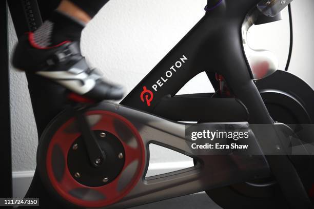 Cari Gundee rides her Peloton exercise bike at her home on April 06, 2020 in San Anselmo, California. More people are turning to Peloton due to...