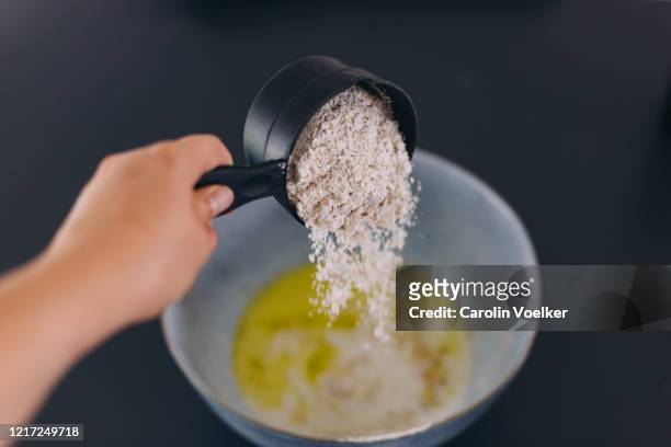 caucasian, female hand pouring flour into a mixing bowl - mixing bowl stock pictures, royalty-free photos & images