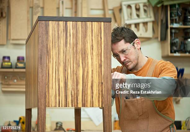 man places finishing details on piece of furniture - carpenter stock pictures, royalty-free photos & images