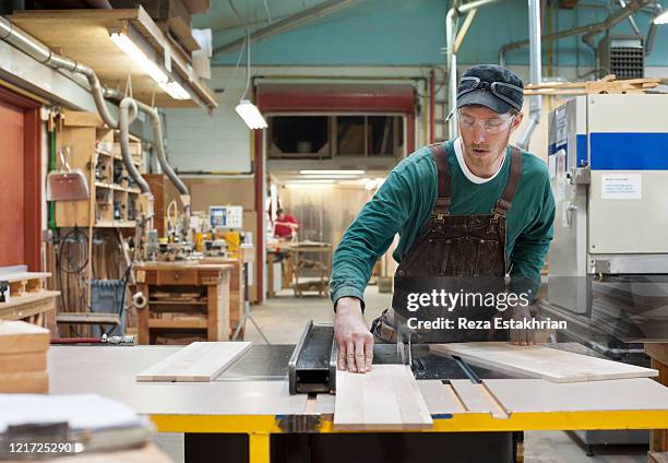 carpenter cuts plank of wood - carpenter stock pictures, royalty-free photos & images