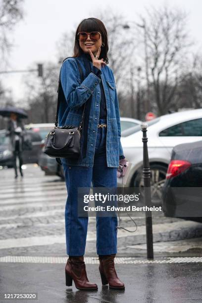 Leaf Greener wears sunglasses, a scarf, earrings, a blue denim jacket, a black leather Chloe bag, a golden chain belt, blue denim cropped jeans,...