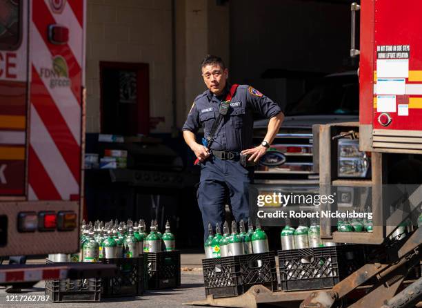 Member of the Fire Department of New Yorks Emergency Medical Team stands next to a resupply of oxygen tanks used in ambulances at the Elmhurst...