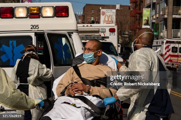 Members of the New York Police Department transport a sick prisoner in handcuffs to a private ambulance outside the emergency room of the Elmhurst...