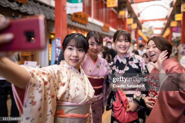 jeunes femmes dans le kimono prenant la photo de selfie dans la rue japonaise traditionnelle de magasinage - quartier d'asakusa photos et images de collection