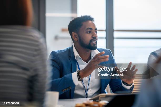 afrikanischer geschäftsmann erklärt mitarbeitern ideen - member meeting stock-fotos und bilder