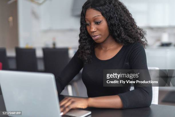 a portrait of a beautiful african american is working out her budget savings plan - survival rate stock pictures, royalty-free photos & images