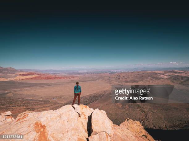 a young women stands atop juniper peak in red rocks canyon state park, nevada - über etwas schauen stock-fotos und bilder