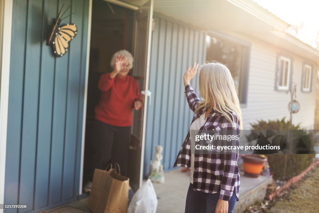 Mature Adult Female Delivering Groceries to Senior Adult Female and Social Distancing Due to Infectious Virus Outbreak Pandemic