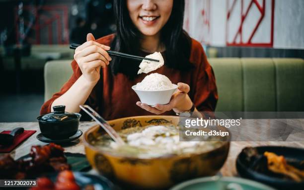 smiling young asian woman enjoying traditional chinese szechuan cuisine, boiled fish with pickled cabbage and a variety of other dishes in a restaurant - female eating chili bildbanksfoton och bilder