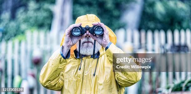 yellow raincoat sea mariner sailor looking at camera through binoculars - looking through lens stock pictures, royalty-free photos & images