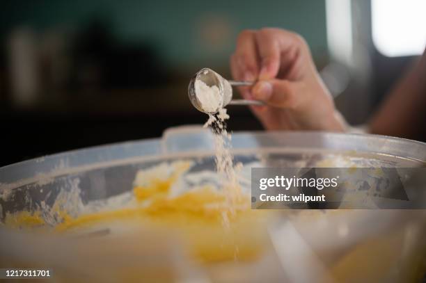 add baking powder soda to the mix close-up - baking soda stock pictures, royalty-free photos & images