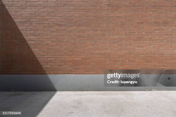 empty street and brick wall - empty street stock pictures, royalty-free photos & images