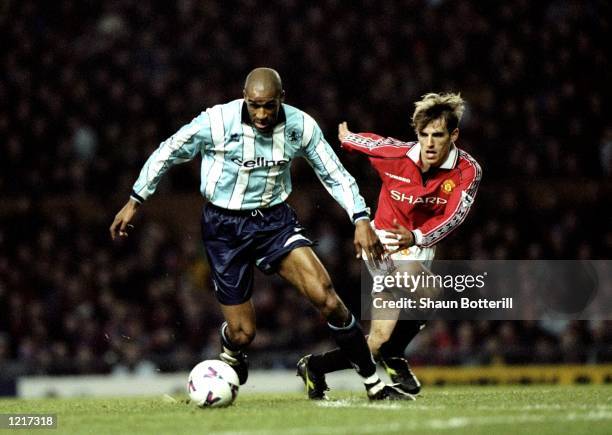 Brian Deane of Middlesbrough holds off the challenge from Philip Neville of Manchester United during the FA Carling Premiership match against...