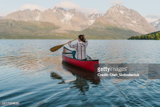 vrouw die op fjord in noorwegen kanovaren - kano stockfoto's en -beelden