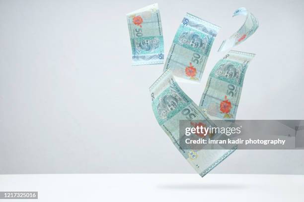 multiple ringgit malaysia falling down with copy space - malaysian ringgit stock pictures, royalty-free photos & images