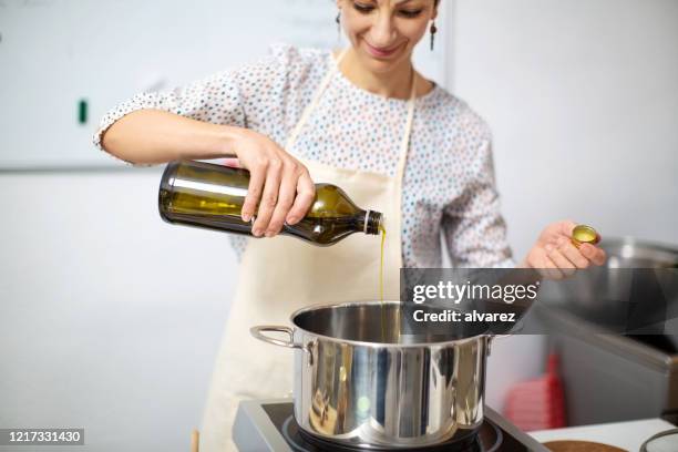 weibliche köchin koch essen in der küche - kochgeschirr stock-fotos und bilder