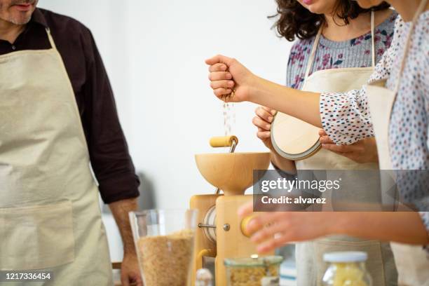 chef showing pasta flour preparation with hand mill to a couple - pouring cereal stock pictures, royalty-free photos & images