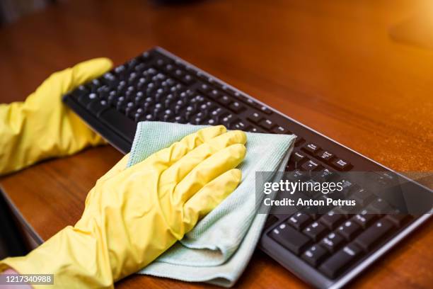 woman in rubber gloves disinfects the keyboard - dirty computer keyboard stockfoto's en -beelden