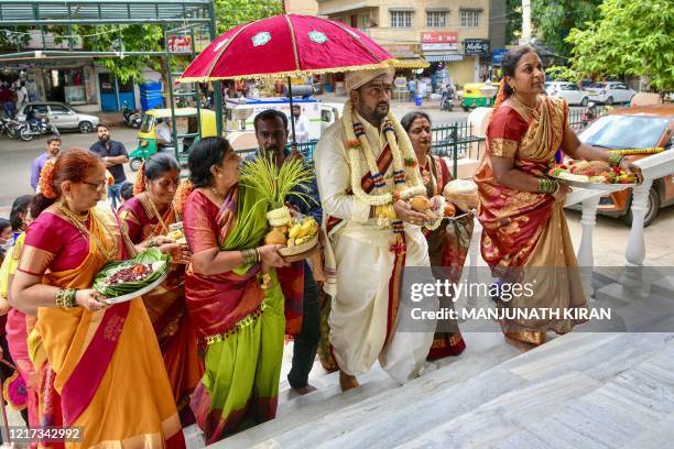 Family members of the bride welcome the groom and his family as per the ritual during a traditional Hindu wedding, after the governement eased a...