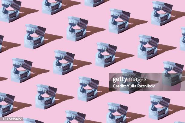 repeated dental model on the pink background - rhythm stock-fotos und bilder