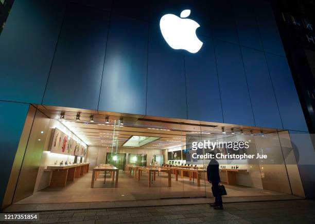 Businessman looks at a temporary closure notice posted in front of the entrance of the Apple store in Tokyo's upscale Ginza district on April 07,...