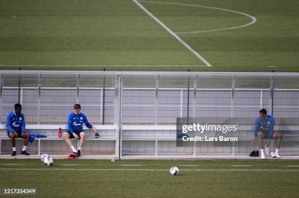 Rabbi Matondo and Bastian Oczipka hold distance while changing their shoes during a training session at FC Schalke 04 training ground on April 07,...