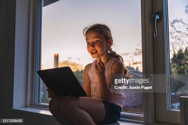 Young girl using digital tablet by window