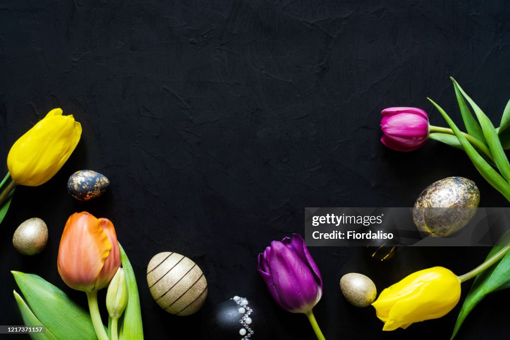 Chicken, quail eggs dyed in black paint, gold and covered with gold leaf for gilding, tulips