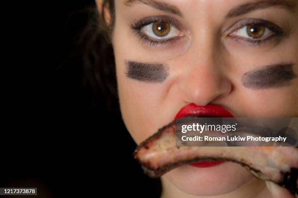 female with lipstick eating bbq ribs - afl woman foto e immagini stock