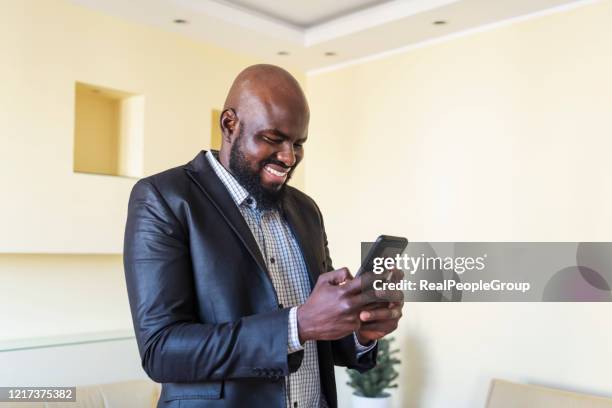 mann liest e-mail auf dem smartphone - real businessman isolated no smile stock-fotos und bilder