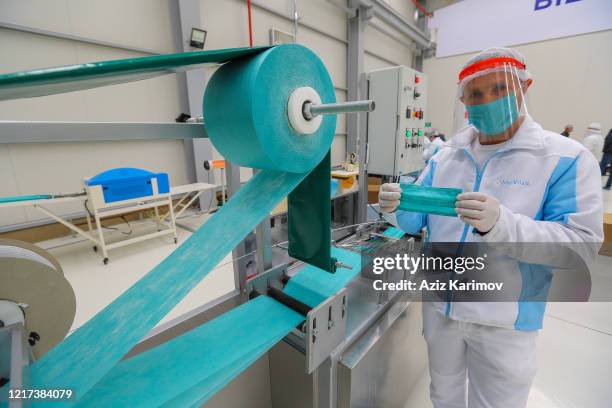 Workers produce face masks at "Baku Textile Factory" company at Sumgait Chemical Industrial Park on April 7, 2020 in Baku, Azerbaijan. The...