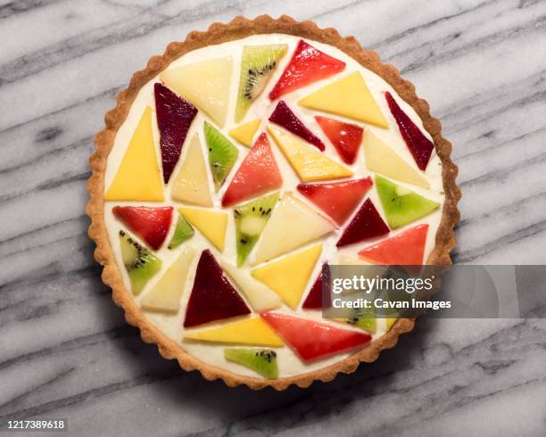 abstract fruit tart with mango, kiwi, plum, and peach - fruit tart stock-fotos und bilder