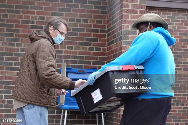 Resident casts a ballot outside of Roosevelt Elementary School on April 07, 2020 in Racine, Wisconsin. The polling place was set up to offer drive-up...