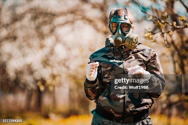 a female soldier wearing a gas mask at the time of covid-19 - conflict zone stock pictures, royalty-free photos & images