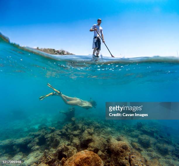 young couple have a fun in ocean water, underwater view - denpasar stock pictures, royalty-free photos & images