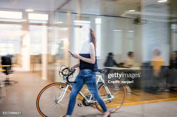 onderneemster die aan het werk met fiets aankomt - inside the bicycle corporation of america assembly facility stockfoto's en -beelden