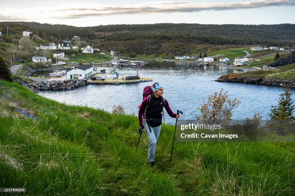 Female Backpacker Hiking Near Small Town On East Coast Trail