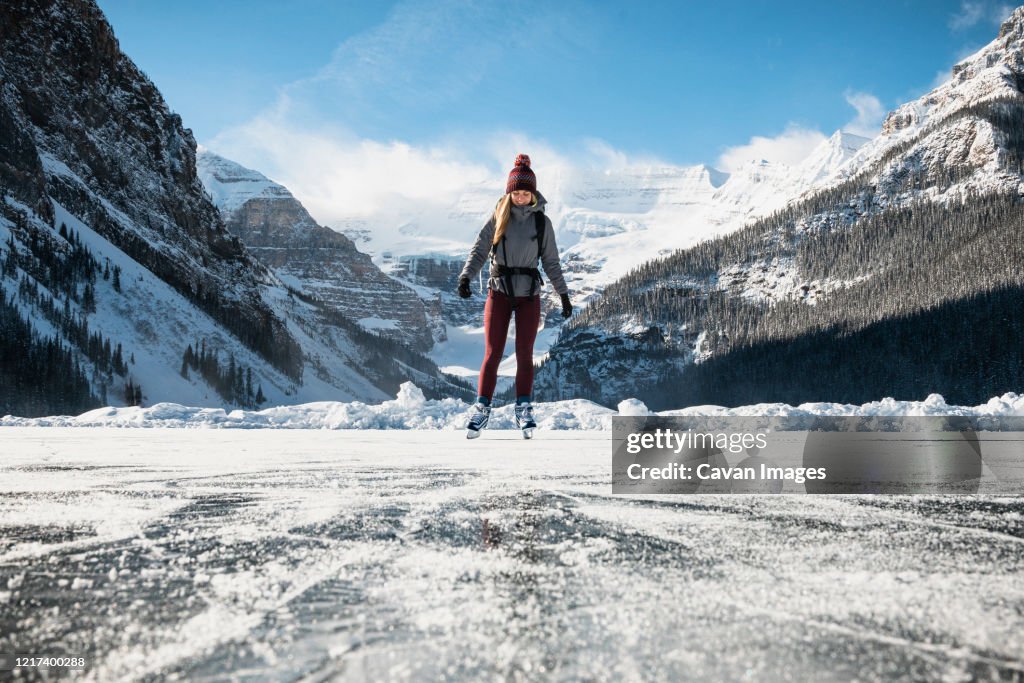 Woman Ice Skating on Frozen Lake at Lake Louse in Banff National Park