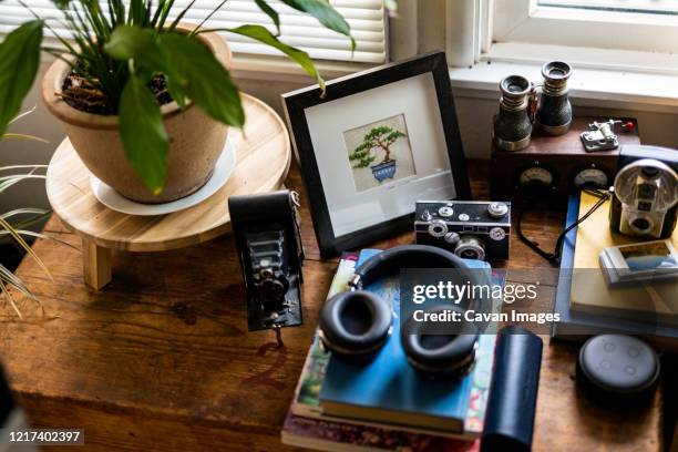 assorted belongings on wood surface inside home near window light - bezittingen stockfoto's en -beelden