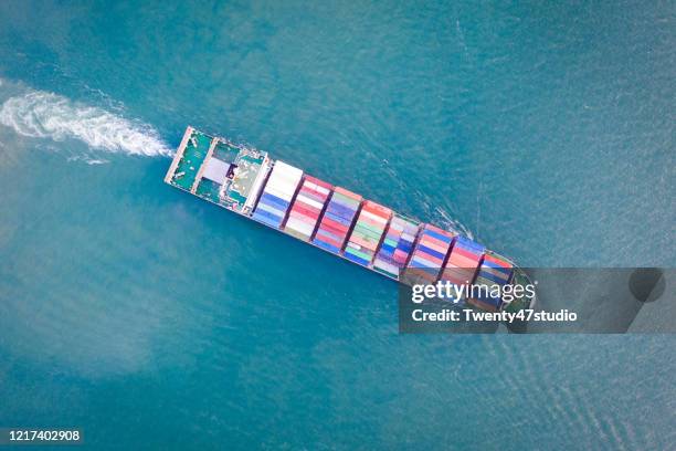 aerial view of freight ship with full cargo containers on the sea - docklands studio stock pictures, royalty-free photos & images