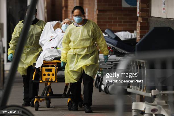 Medical workers take in patients at a special coronavirus intake area at Maimonides Medical Center on April 07, 2020 in the Borough Park neighborhood...