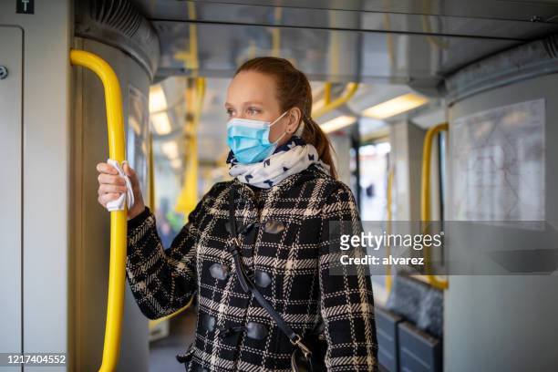 frau mit gesichtsmaske unterwegs in u-bahn während covid-19 ausbruch - pandemic illness stock-fotos und bilder
