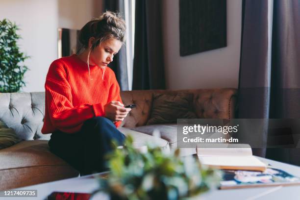 staying home during covid-19 pandemic - young adult mobile phone serious stock pictures, royalty-free photos & images